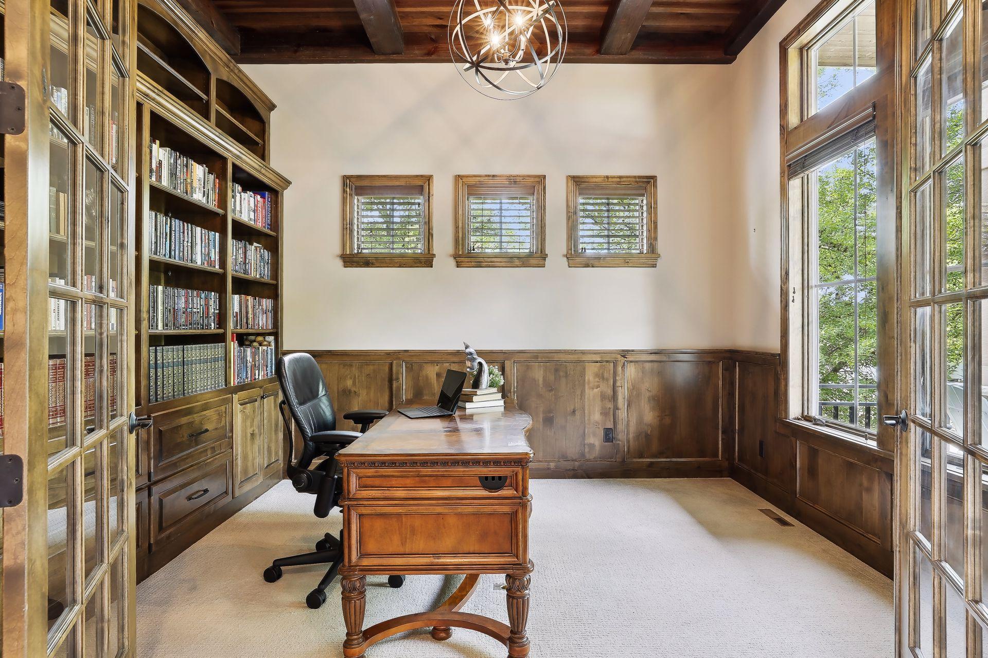 Study with 12' ceilings with wood beams and full wall bookcases.