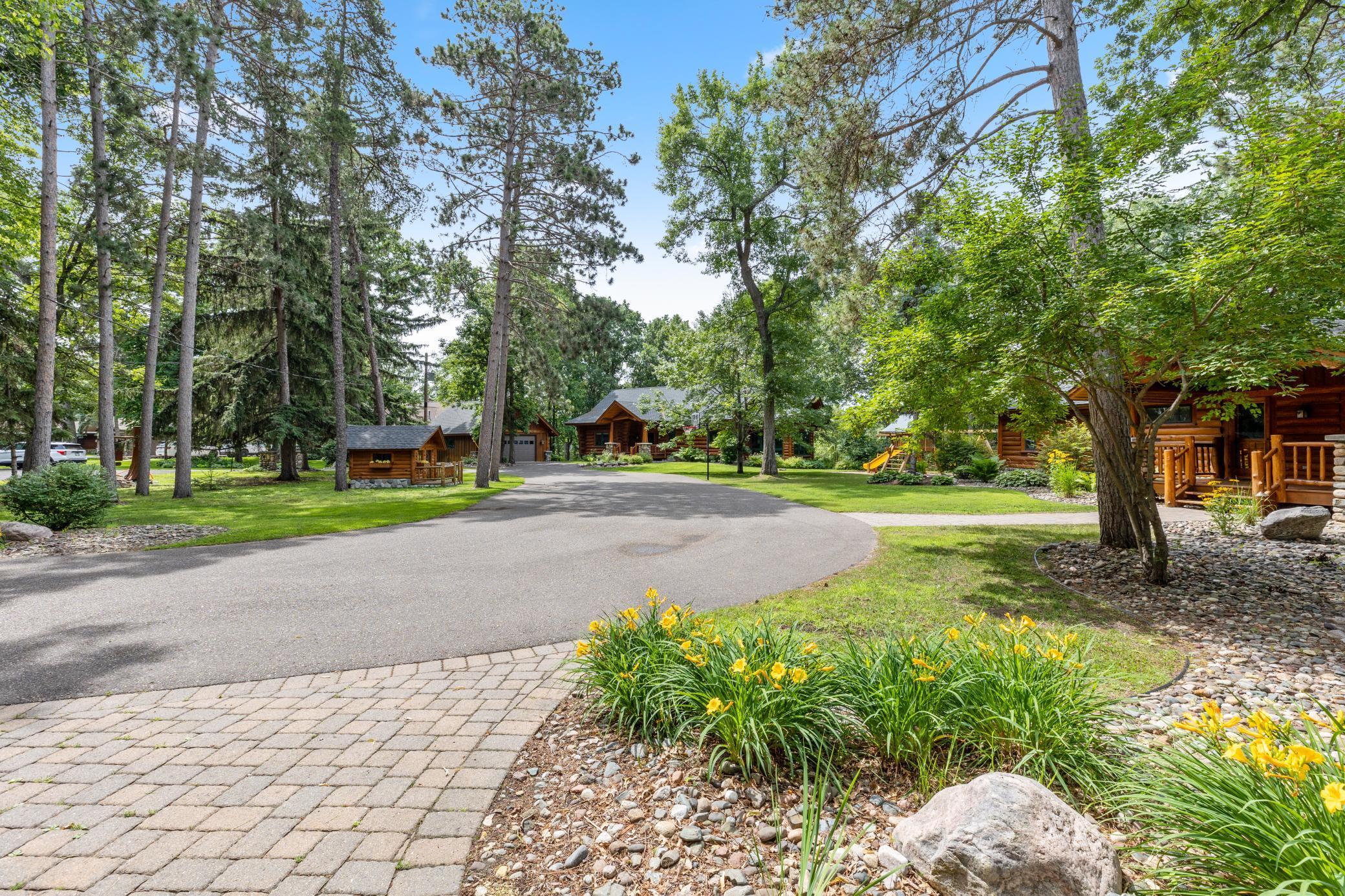The Main Cabin features a three-car attached garage, Bertha Cabin is in the center and Clamshell Cabin features a two-car detached garage. Included with the property the charming log playhouse.