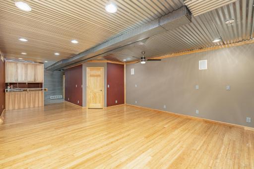 Spacious living area in lower level plus storage behind the door straight ahead. Notice the galvenized steel ceiling with ample lighting.