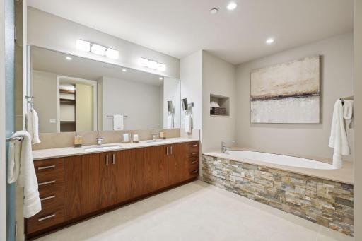 End of the day respite! A bit of Minnesota in stacked limestone was added to the tub surround, to the left of the full wall of storage is the oversized shower.