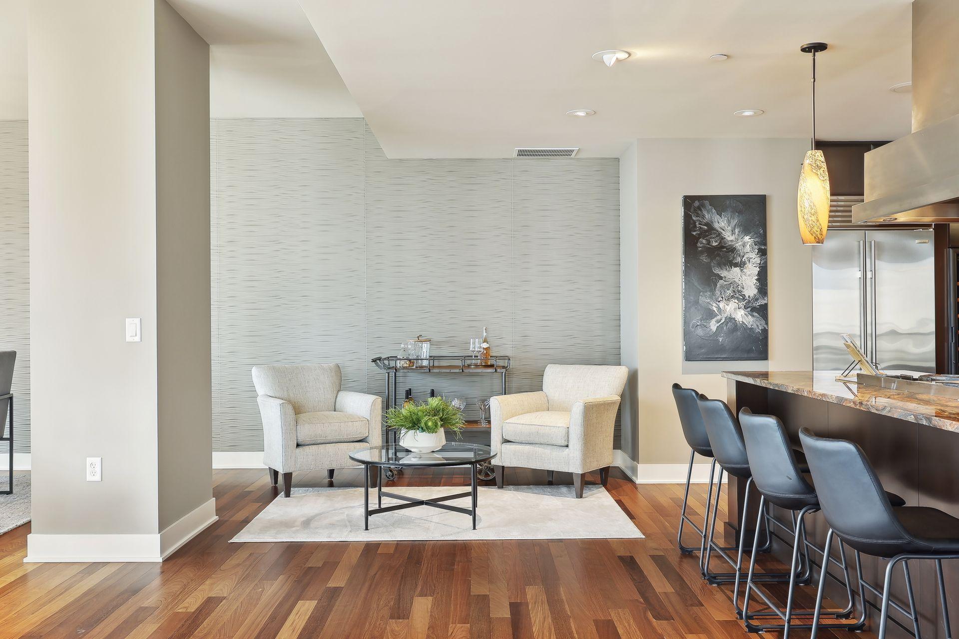 This image shows the pendant lighting over the marble counter and shows the textured artistic wall behind the informal seating area off formal dining and counter dining.