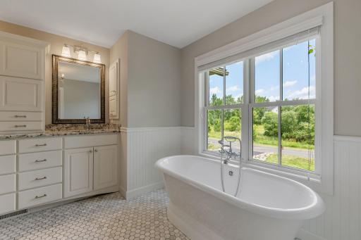 Free standing tub with classic marble mosaic tile flooring