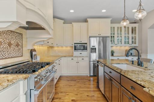Stainless steel appliances include a 48" Electrolux gas range w/ cabinet paneled hood, French door refrigerator, dishwasher and microwave