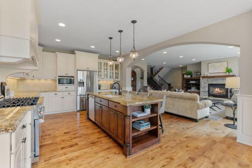 Oversized "Eat-in" center island features select alder cabinetry, open display shelving and fluted legs
