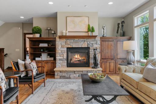 Gas fireplace with rustic cultured stone surround and raised hearth