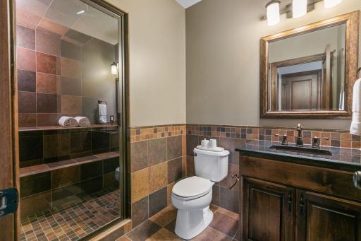 Alder vanity cabinet w/ quartz countertop, copper sink and rustic tile wainscoting and flooring