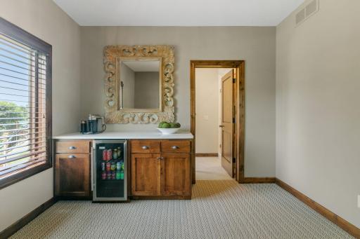 Sitting room offers built-in coffee bar features alder cabinetry, quartz countertop and beverage refrigerator