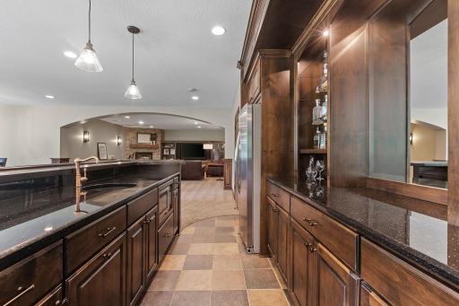 Full bar features alder cabinets, quartz countertops w/ granite composite sink