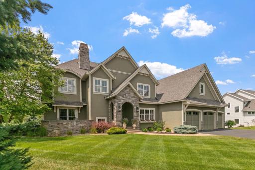 The front facade showcases a mix of stucco siding and stone, while the rest of the home is enveloped in cement lap siding for durability and timeless appeal.