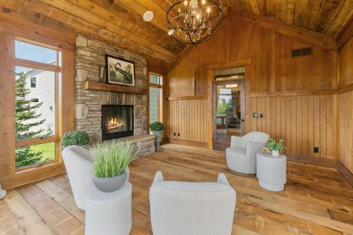 Wood burning fireplace w/ rustic cultured stone surround, raised hearth and a reclaimed barn wood mantel