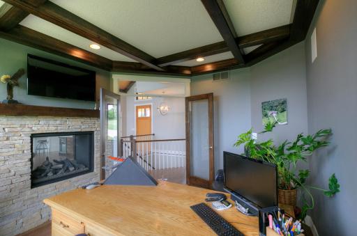 Ceiling has exposed beams and the door has a transom window.