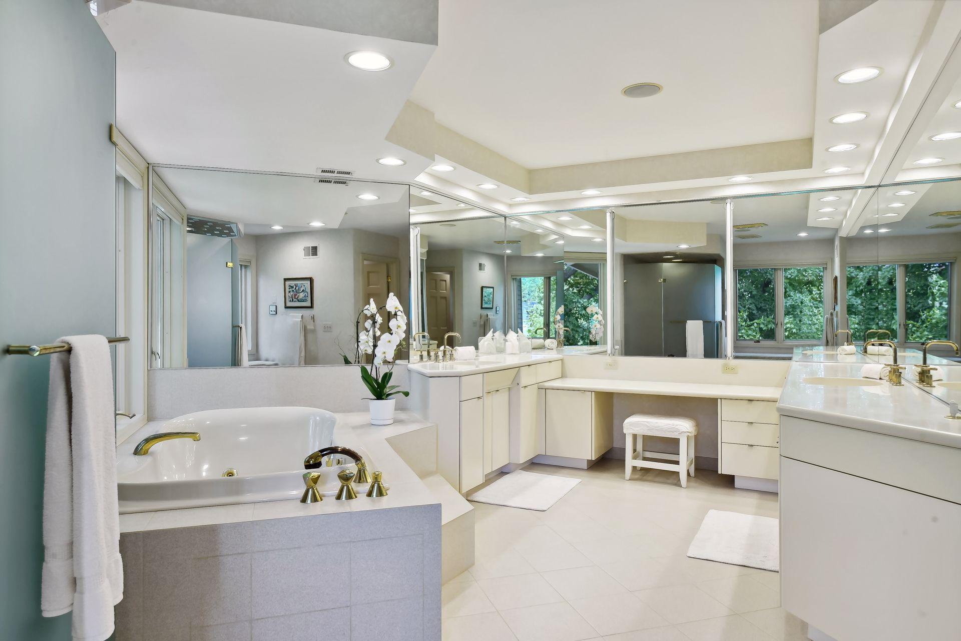 Primary bath with jacuzzi tub, large walk-in shower, and dual vanities.