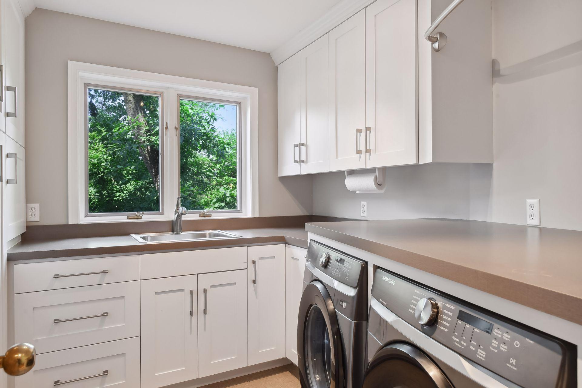 Spacious laundry on the main level with wall of cabinet storage space