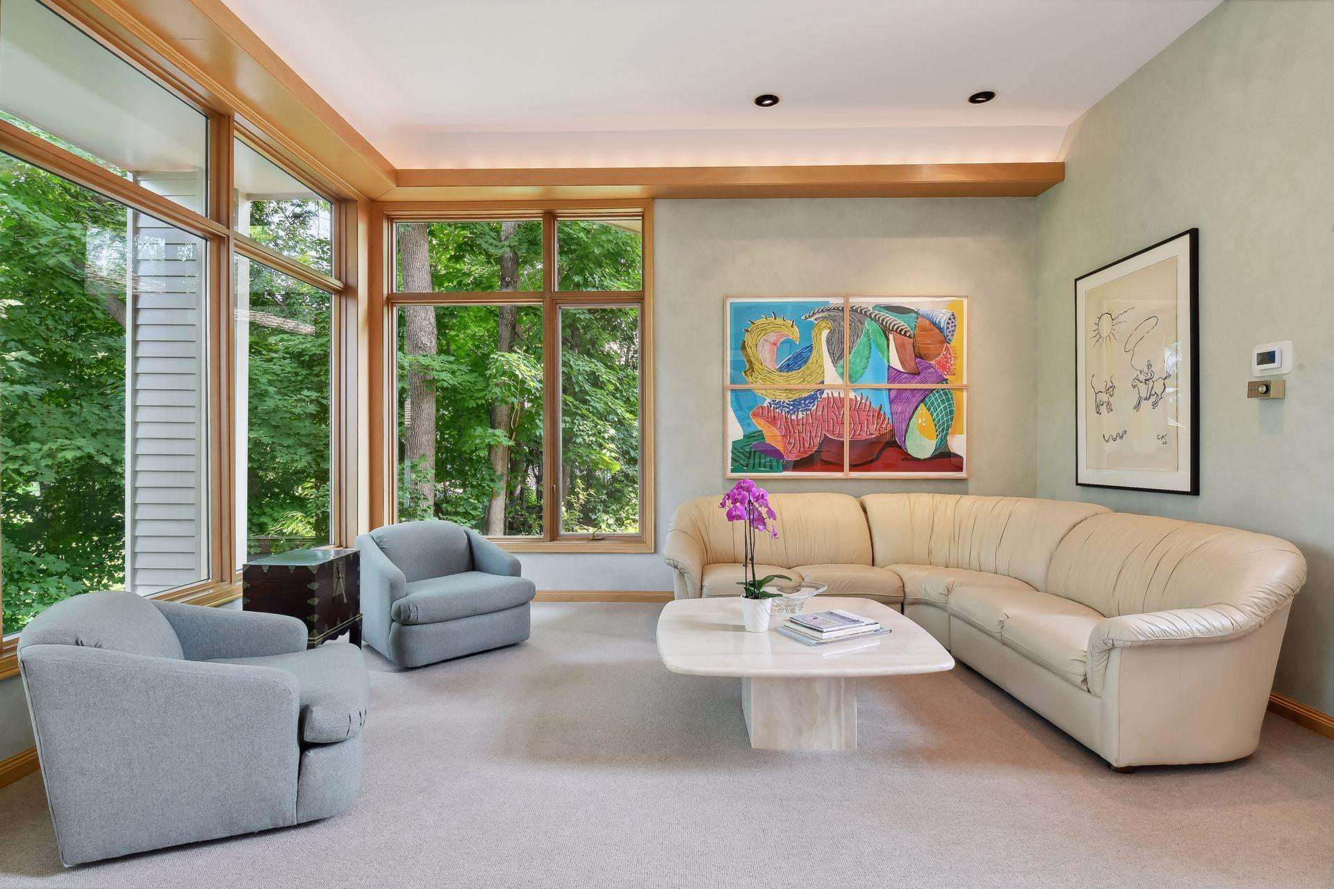Floor-to-ceiling windows with views of mature trees.