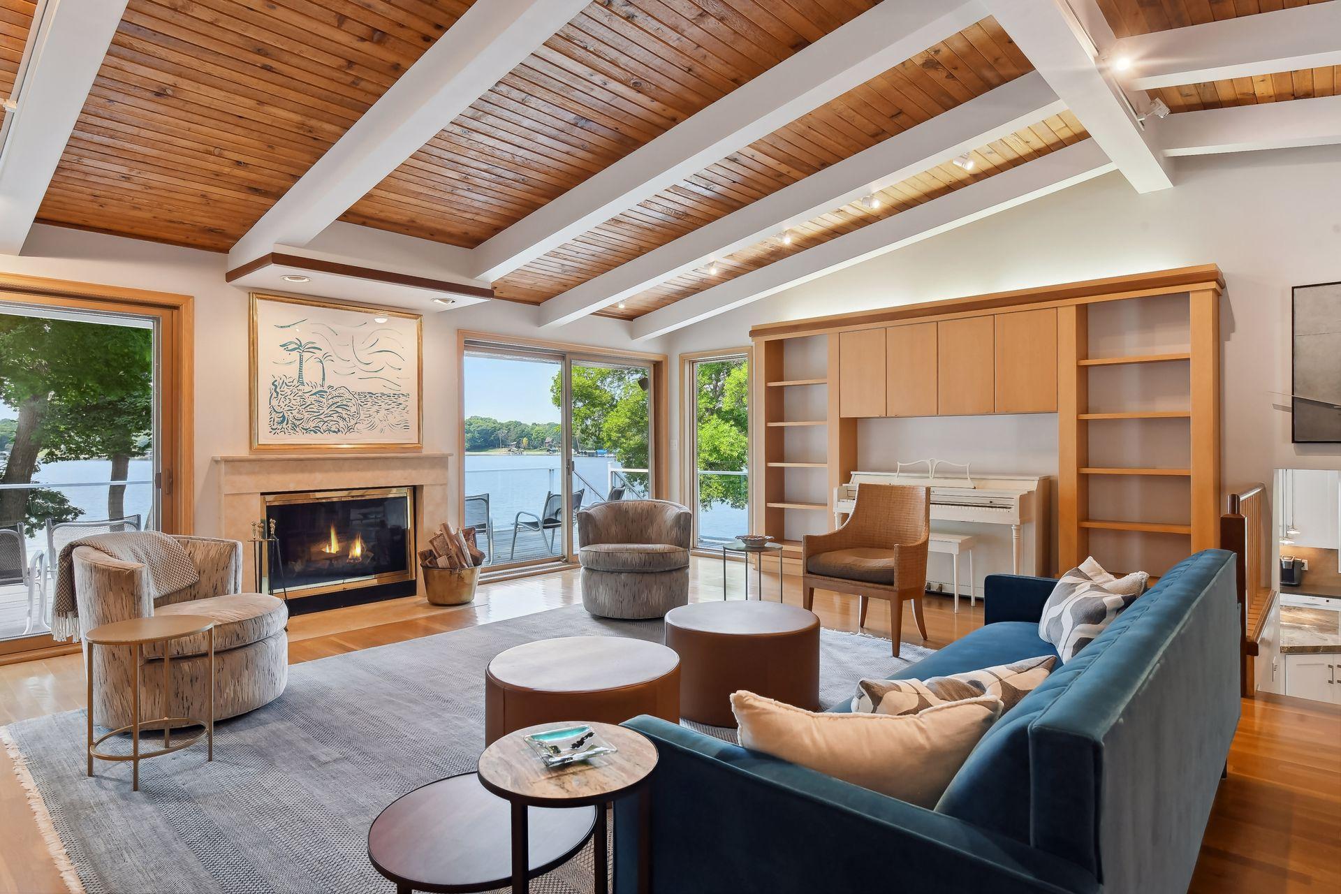 Lake facing living room with wood-paneled vaulted ceilings.