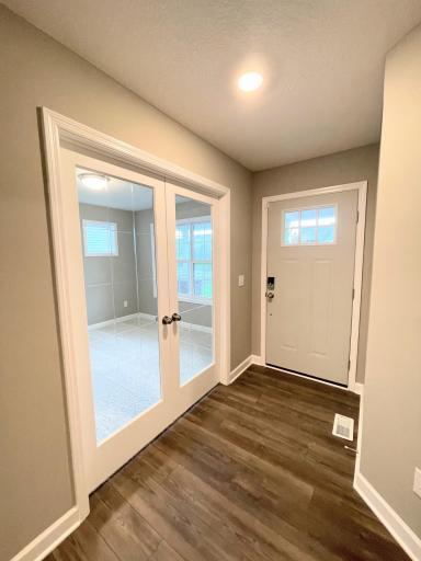 Glassed French doors set off the front entry with light streaming through. Photos are of the actual, available home.