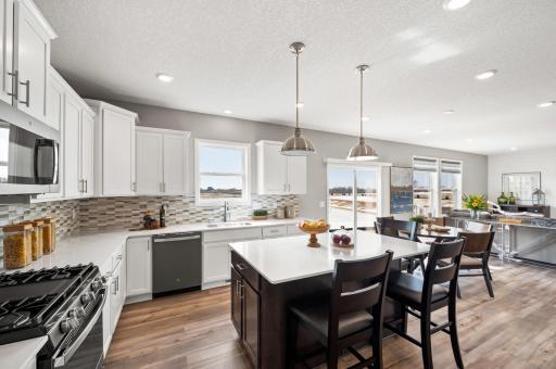 This spacious and open main level seamlessly connects to the kitchen area, perfect for entertaining. It also features many large windows providing abundant natural light. Photo of identical Lewis floorplan. Actual home finishes may vary.