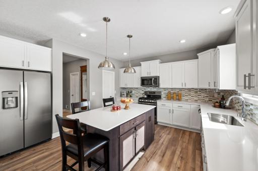 Enjoy plenty of seating at the kitchen island and dining area adjacent to the kitchen. Perfect for entertaining or having a family meal together. Photo of identical Lewis floorplan. Actual home finishes may vary.