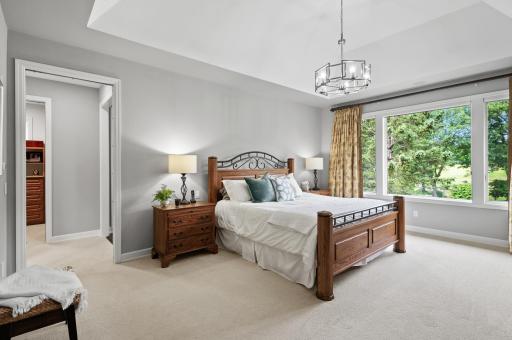 The primary bedroom has vaulted ceilings, ample space, and tons of natural light and views.