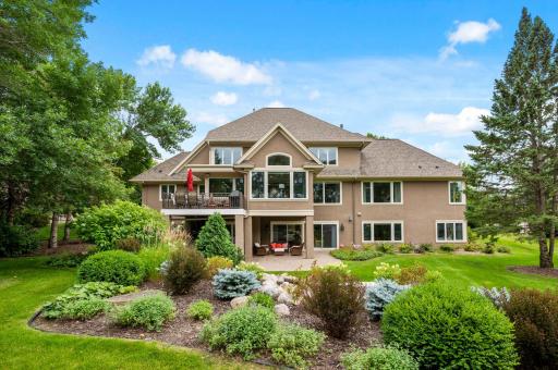 Expansive backyard oasis complete with a covered and uncovered patio, waterfall, and golf course views.