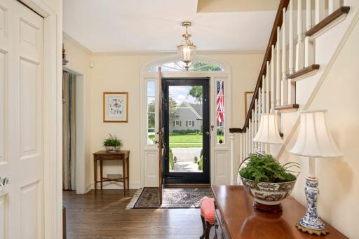 Gracious foyer with a front door with side lights and an arched window