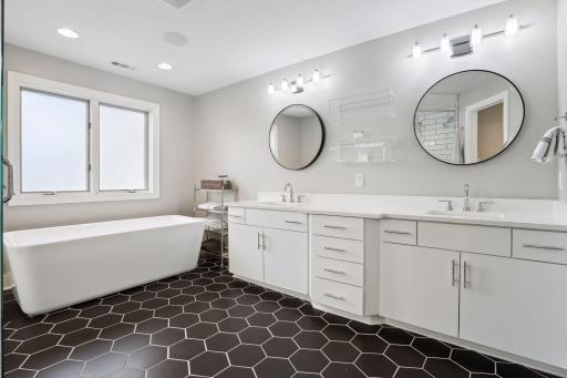 Primary bathroom with dual vanity, soaking tub, and walk-in shower