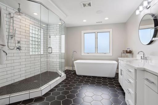 Primary bathroom with dual vanity, soaking tub, and walk-in shower