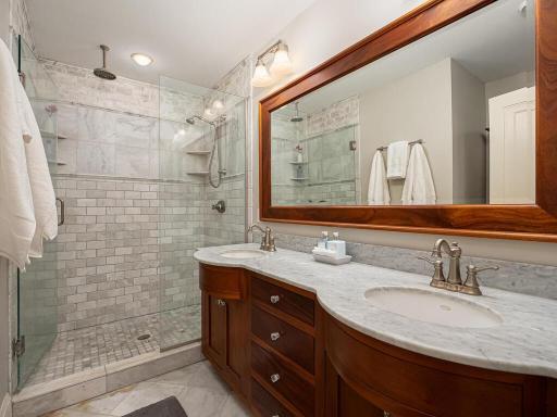 Primary bathroom with rainfall shower head, dual shower heads and double vanity.