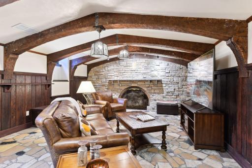 The stone floored pub with beautiful wood beams and stone hearth in the lower level of the home.