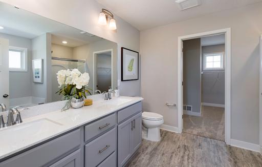 An extension of the owner's suite, this private and spacious bath contains a double-vanity, a soaking tub and a separate shower.