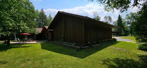 View of part of the deck on the main house and back of the main garage. Lots of beautiful easy to maintain perennial gardens.