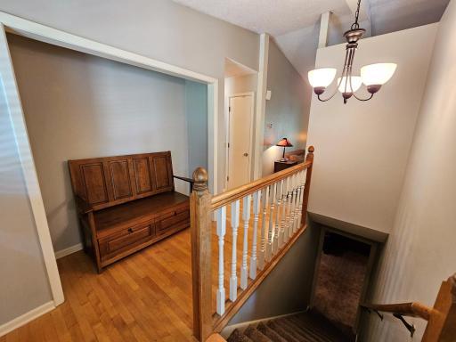The entry to the home has natural hardwood floors and and bench for getting your shoes on and off.