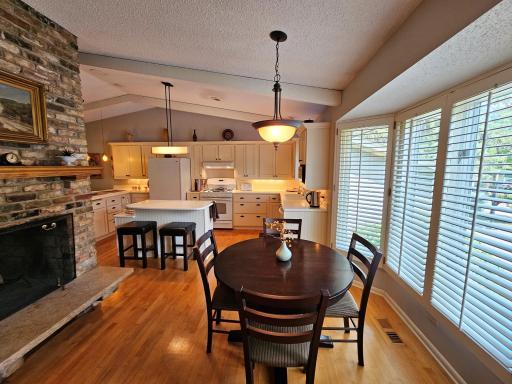 The open eating area connects the home and features a brick fireplace to warm you on winter nights.