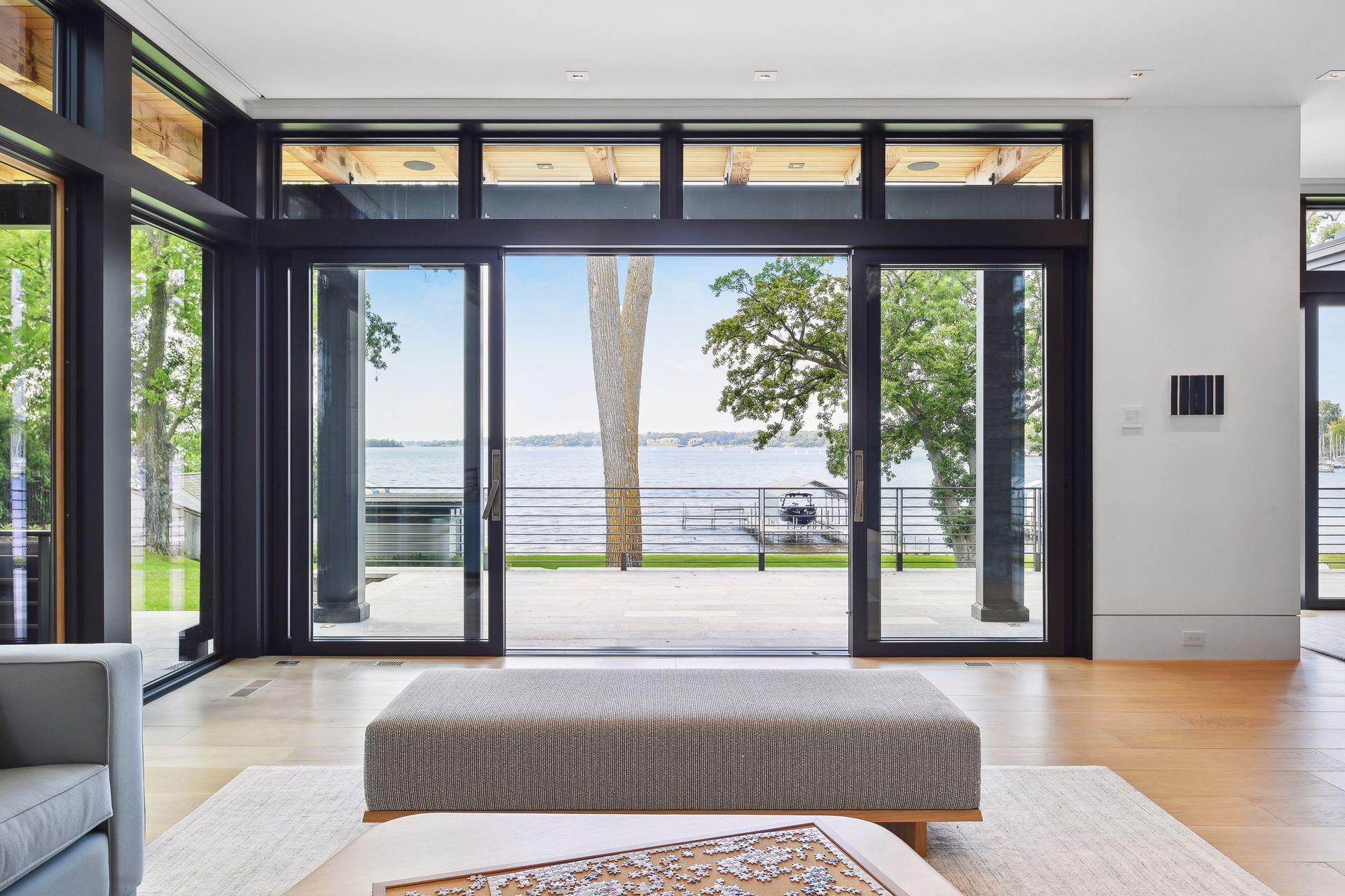 Doors open to stone terrace and lake views