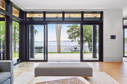 Doors open to stone terrace and lake views
