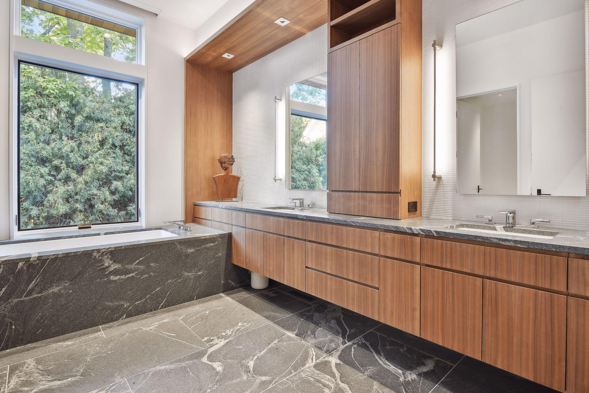 Natural stone and walnut finish the large primary bath