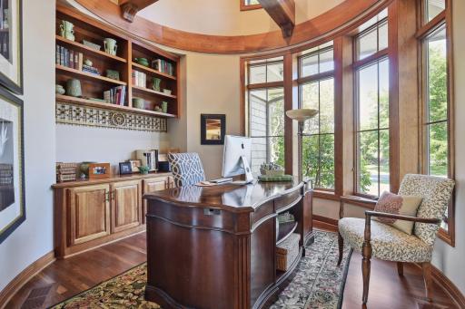 Main floor office with custom circular design and woodwork and built-in shelving