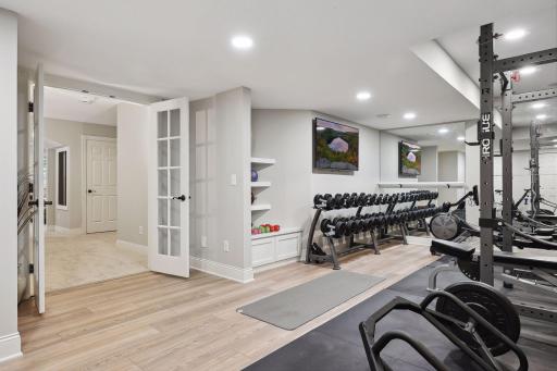 Large home gym with 2 TVs, built in storage and built in speakers connected to SONOS system