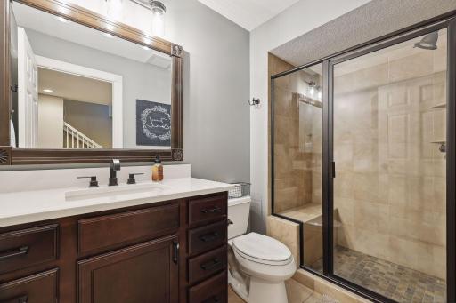 3/4 bathroom in basement with tile shower and heated tile floors