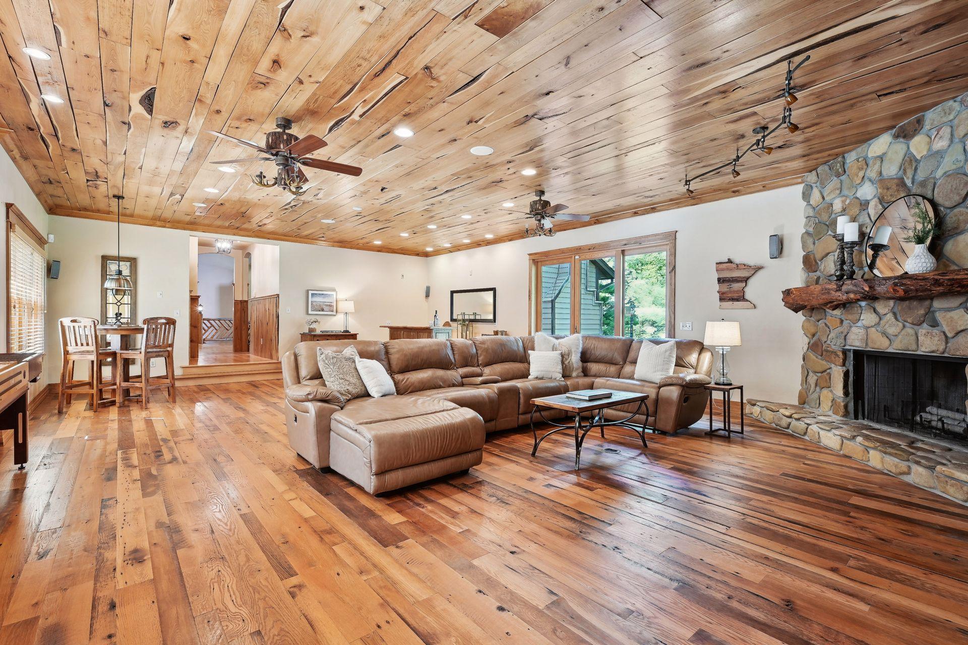 The elements in this room are incredible. Hand sawn flooring, stone surround fireplace and wall, live edge paneling, reclaimed mantle, and so much more.