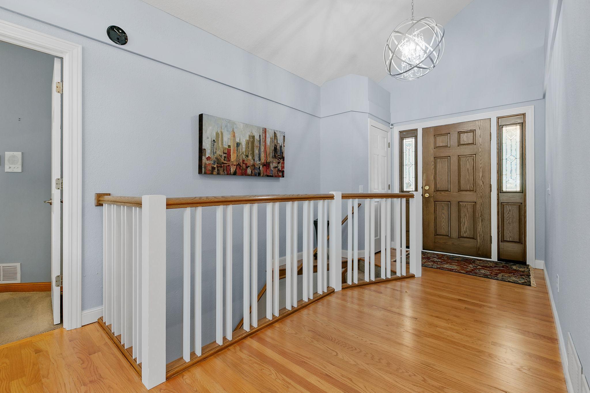 Vaulted Ceilings w/ modern chandelier & oak hardwood flooring