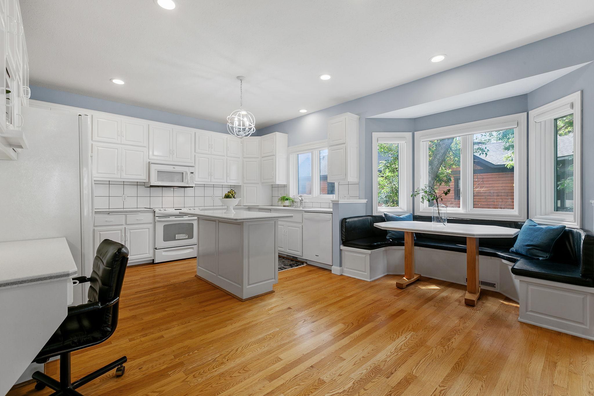 Enameled cabinetry features raised panel doors, full height pantry, appliance garage, roll-out storage, built-in work station and "Eat-In" center island