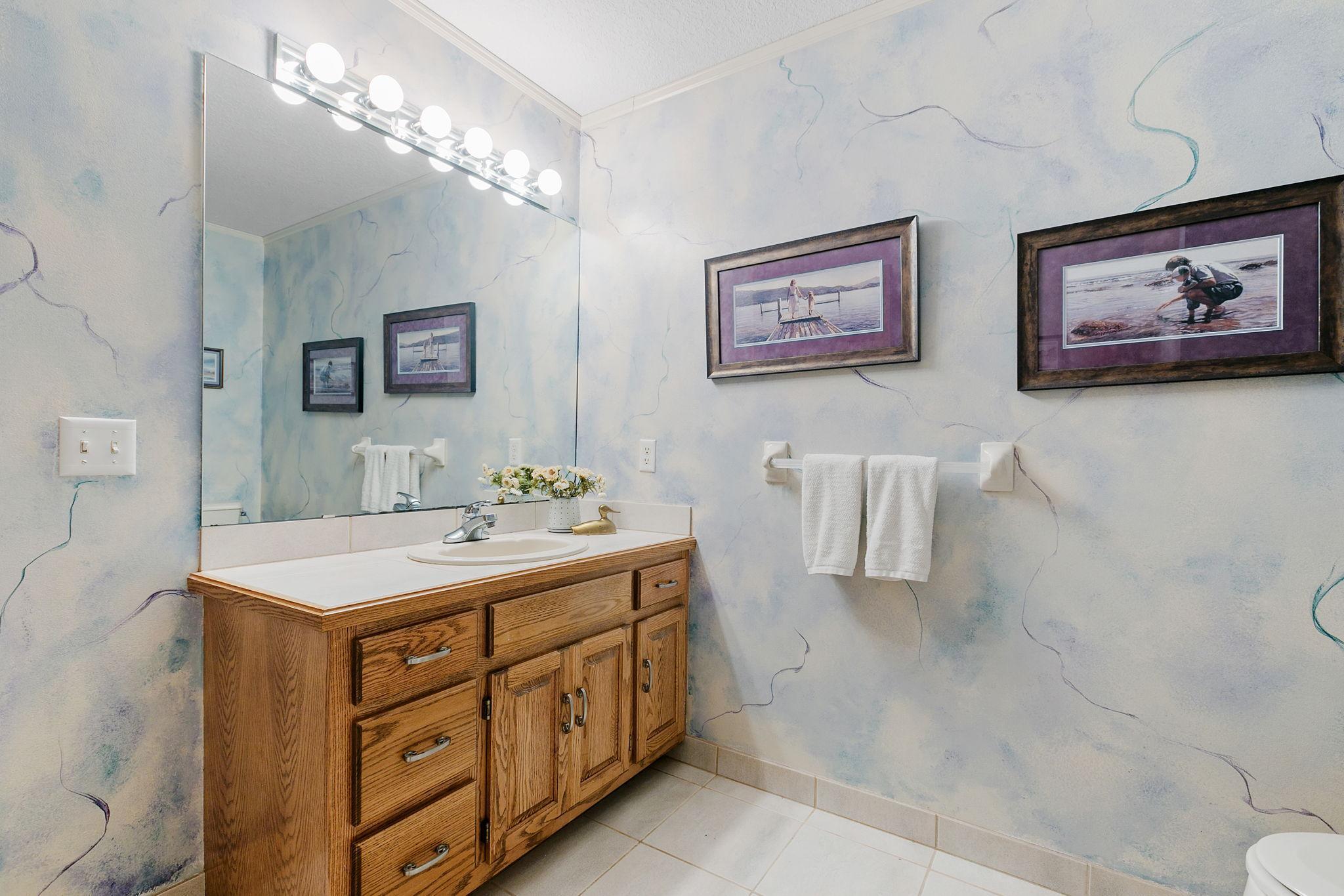 Lower level Full Bathroom w/ oak vanity cabinet and enameled crown molding