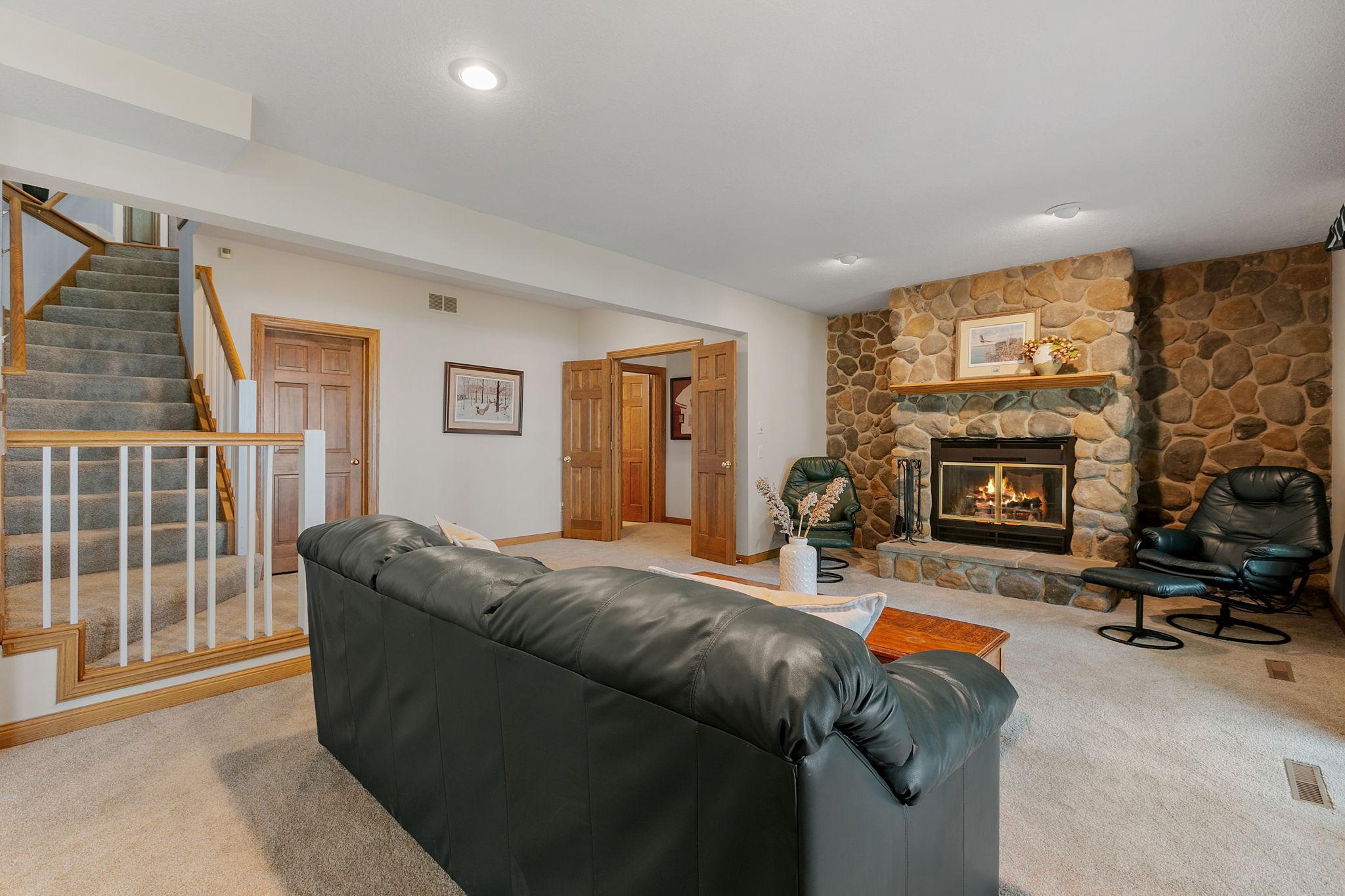Lower level Family Room features a wood burning fireplace w/ cultured stone surround and raised hearth