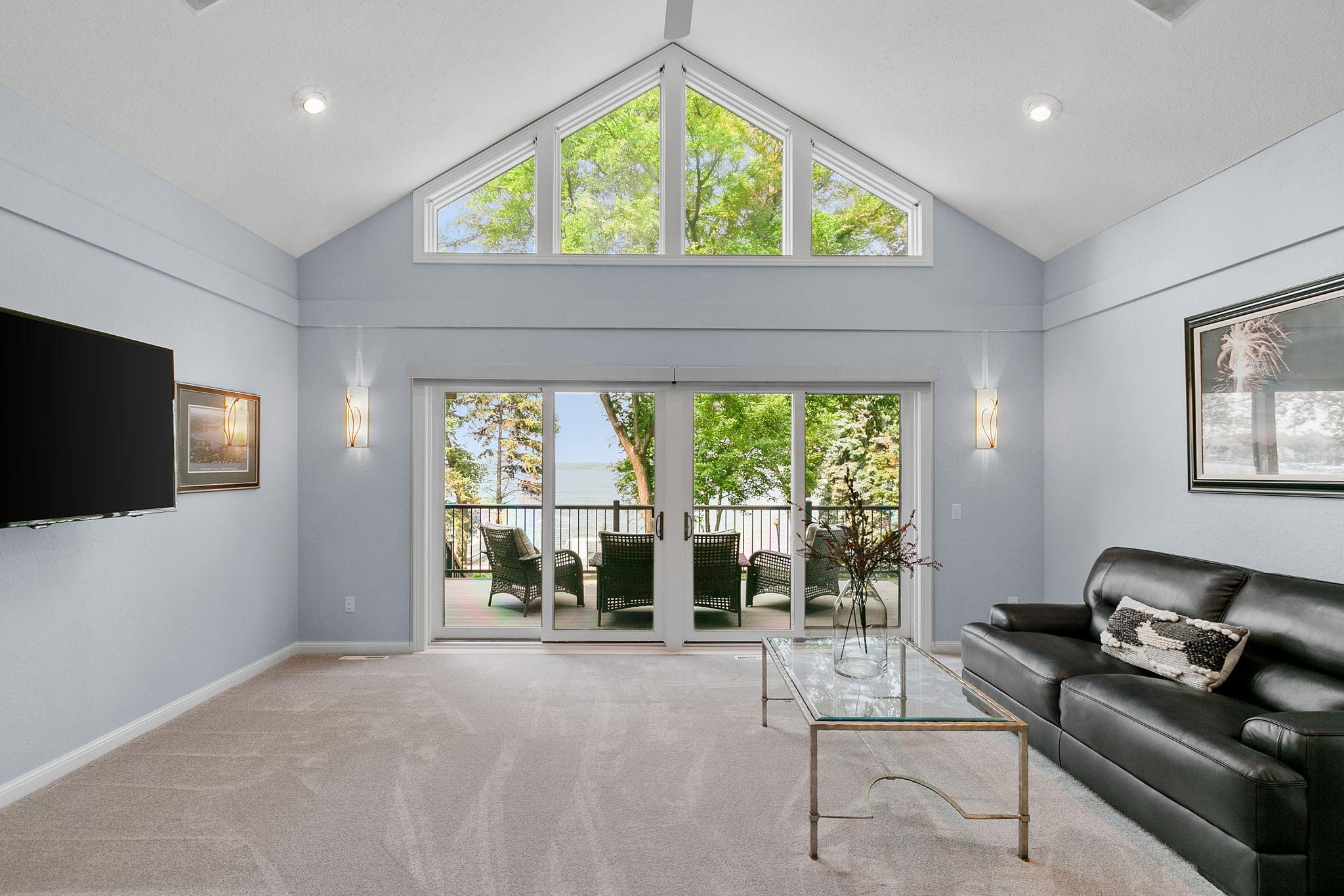 Dramatic vaulted ceilings w/ fan & floor to ceiling windows that capture incredible views of the lake