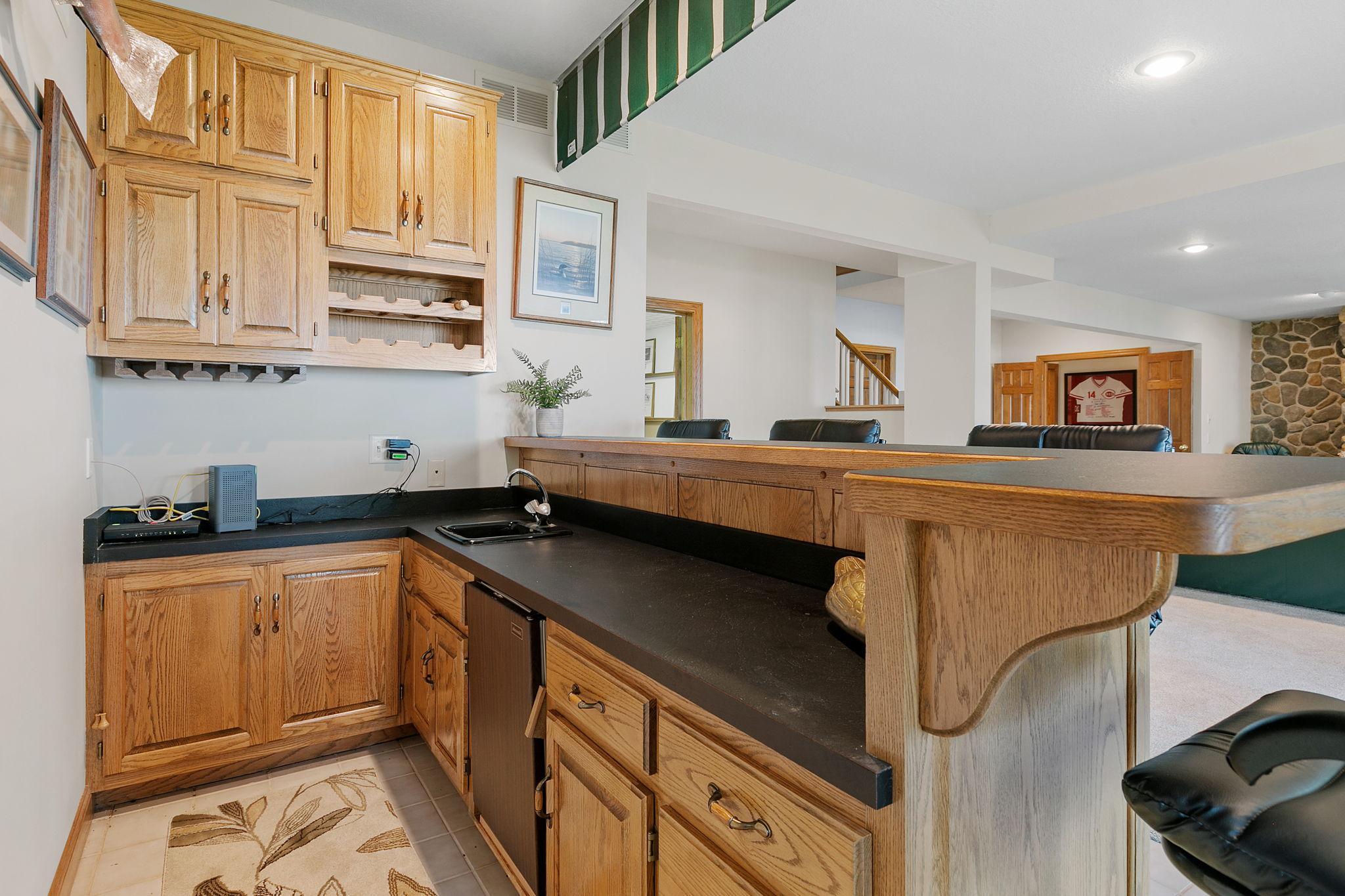 Bar features wine & stemware display, paneled doors, drop-in sink & raised top to accommodate multiple tools
