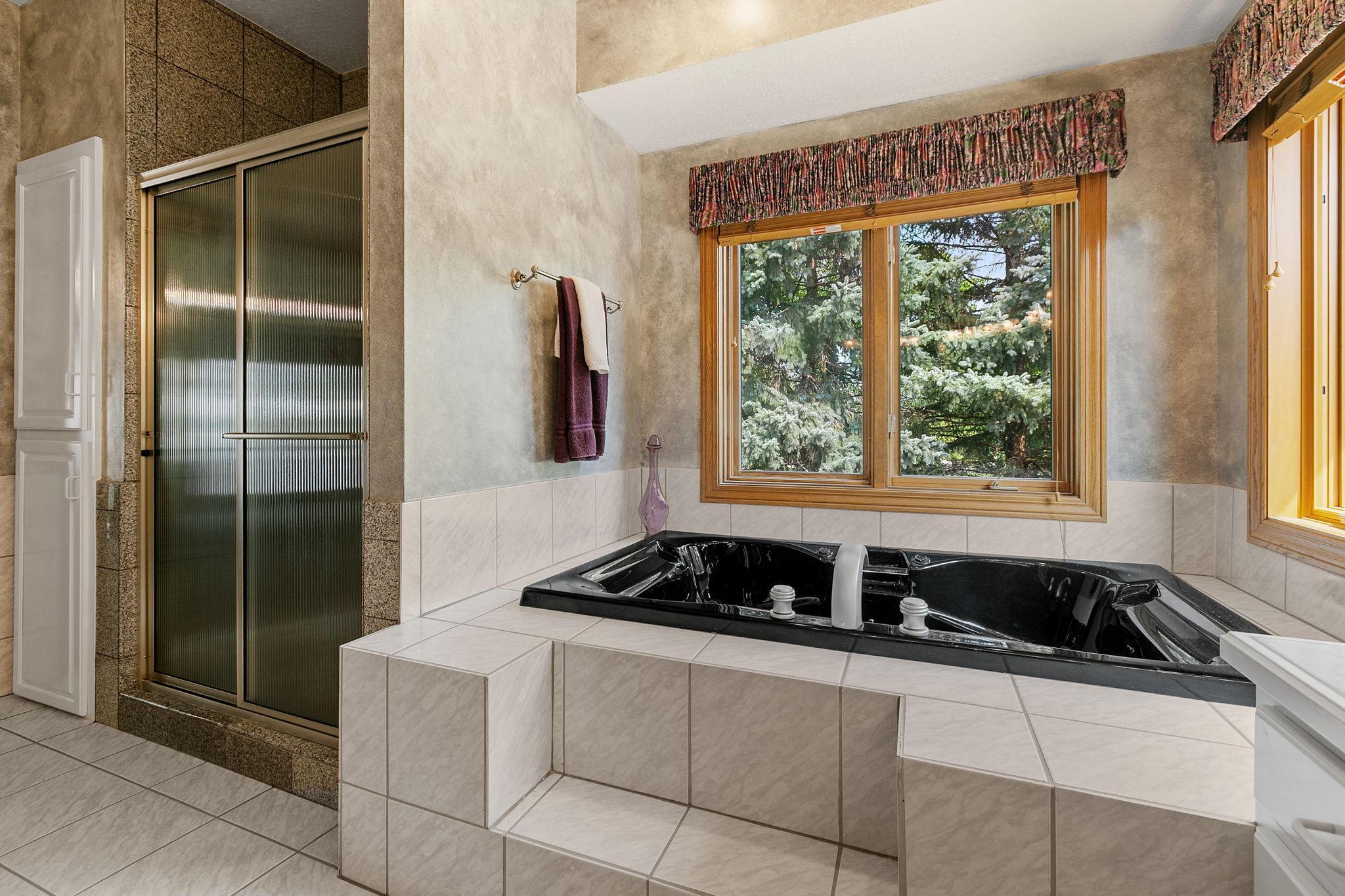 Large, jetted tub situated on a tile deck and surround