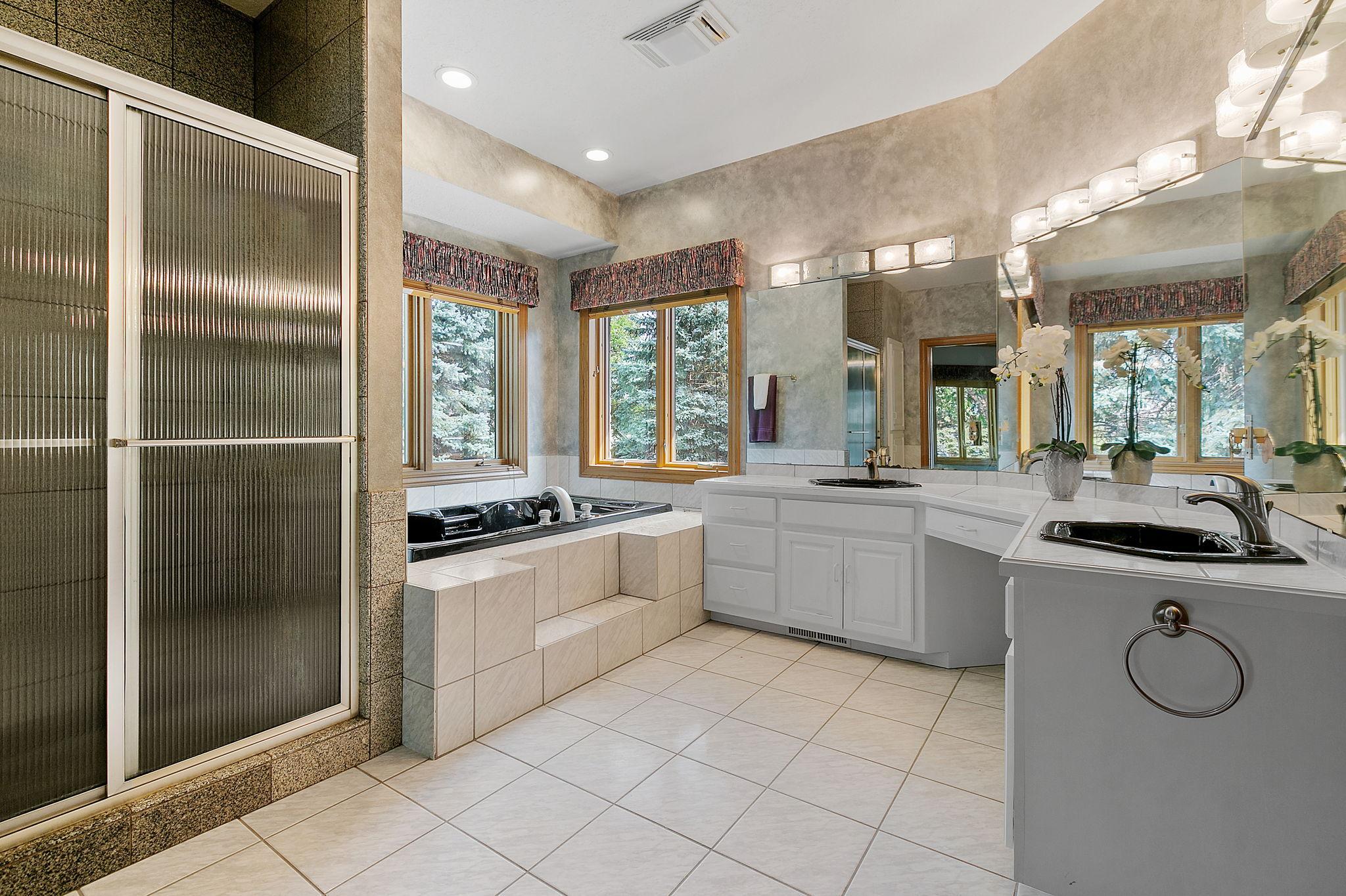 Granite tile shower w/ decorative glass doors