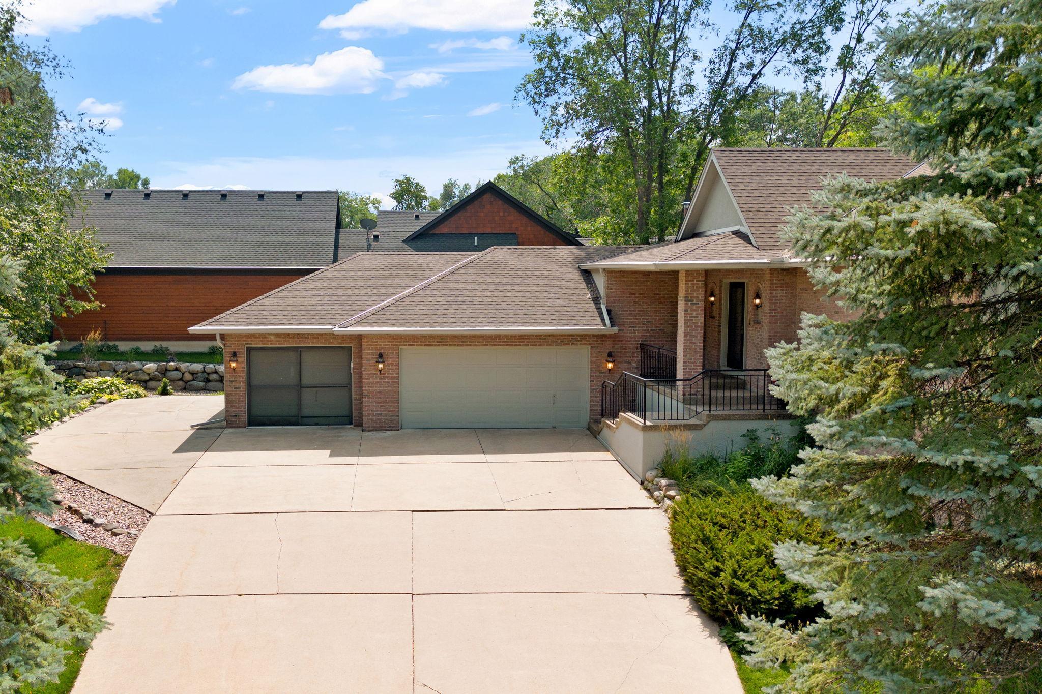 Expansive concrete driveway w/ additional parking space to the side of the garage
