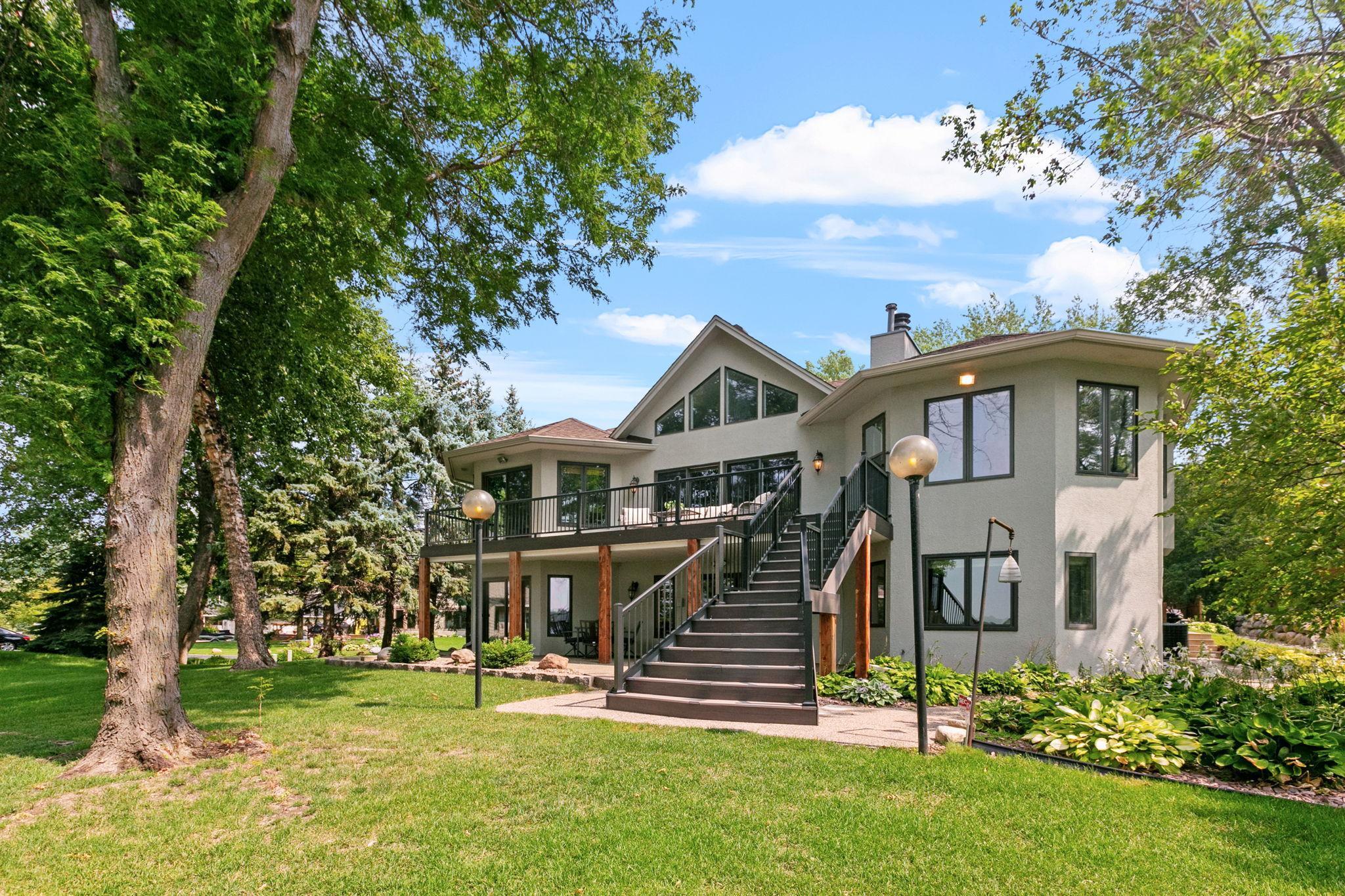 Access to lower level patio from deck and expansive green lawn